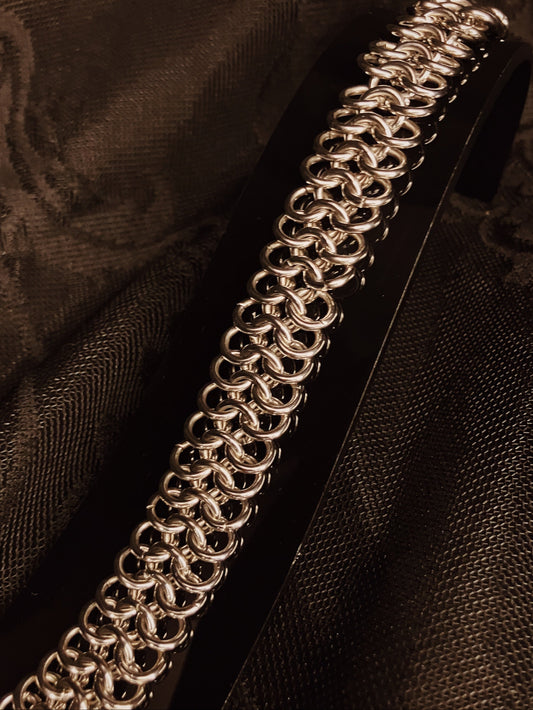 Close-up of a silver chain on a dark fabric background