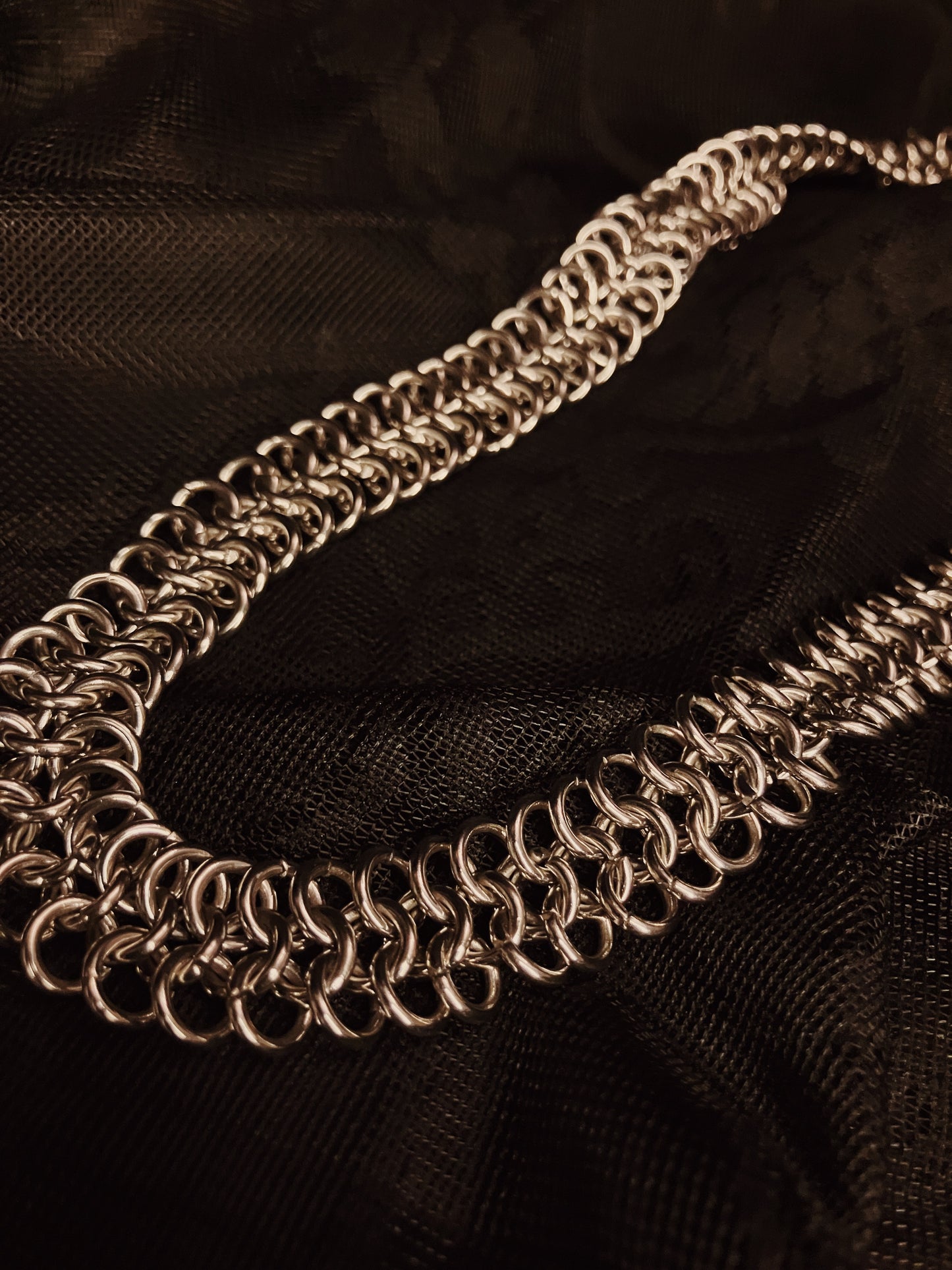 silver chain necklace on black fabric background