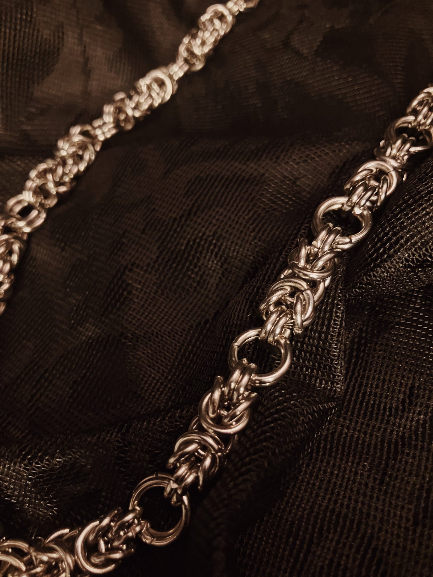 Close-up of a silver chain on black fabric