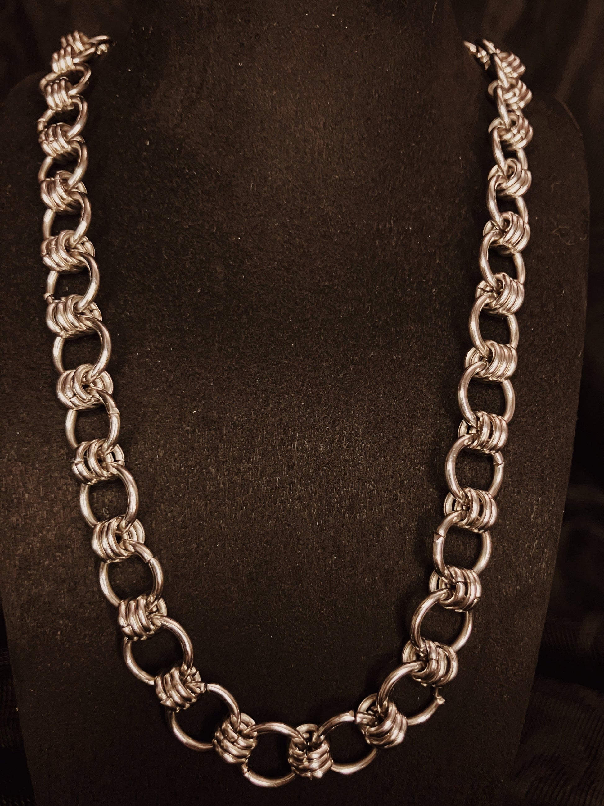 Silver chain necklace on a black background