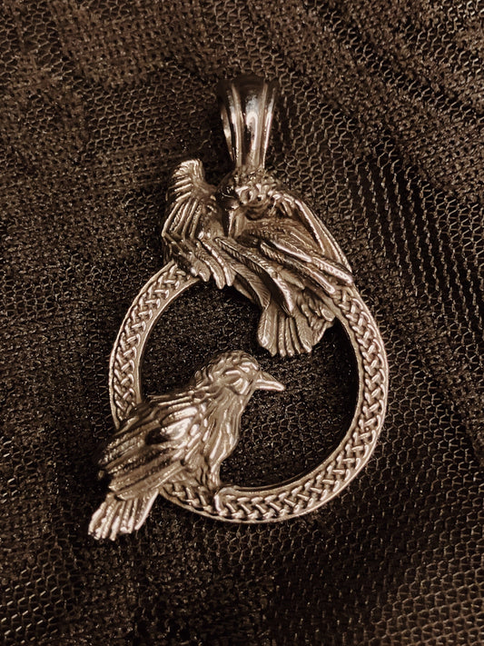 stainless steel pendant with two birds on a textured brown background