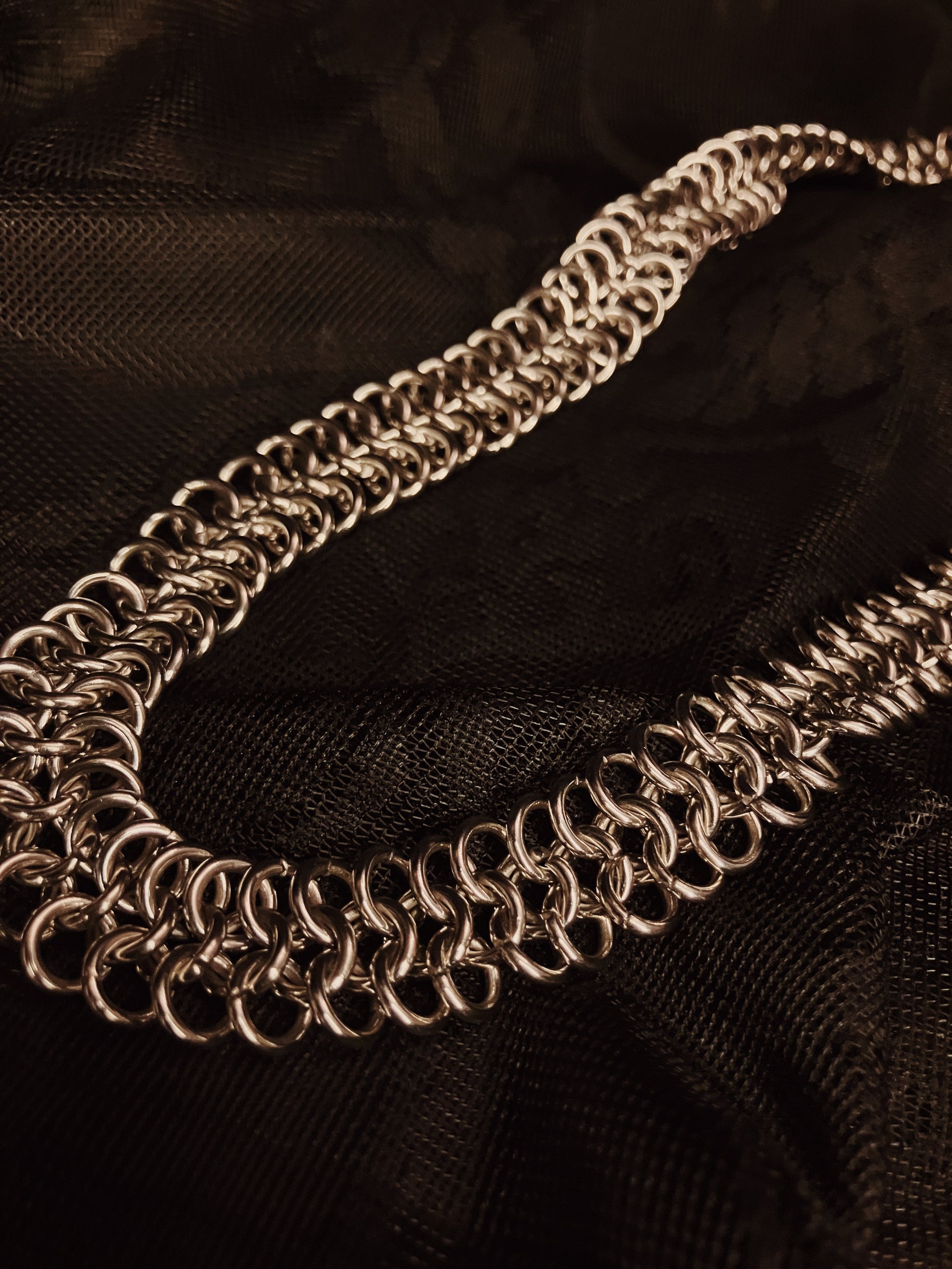 silver chain necklace on black fabric background