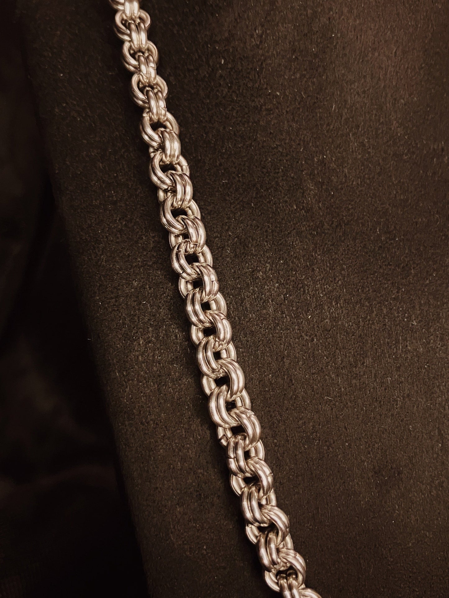 Silver chain necklace on a black background