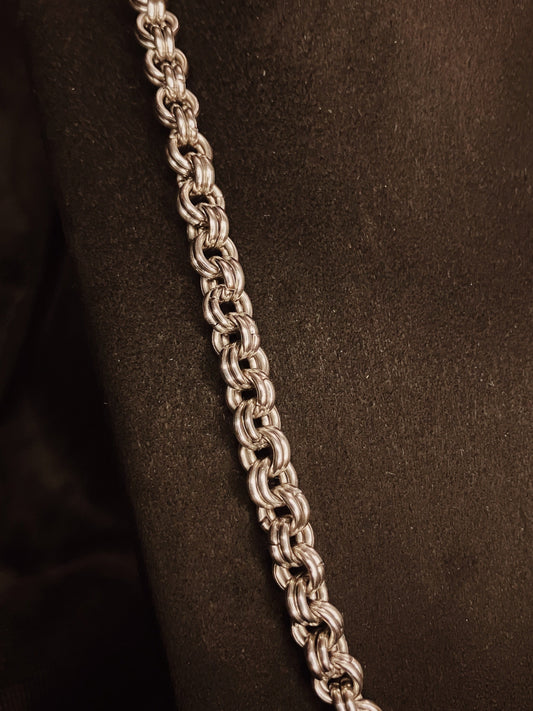 Silver chain necklace on a black background