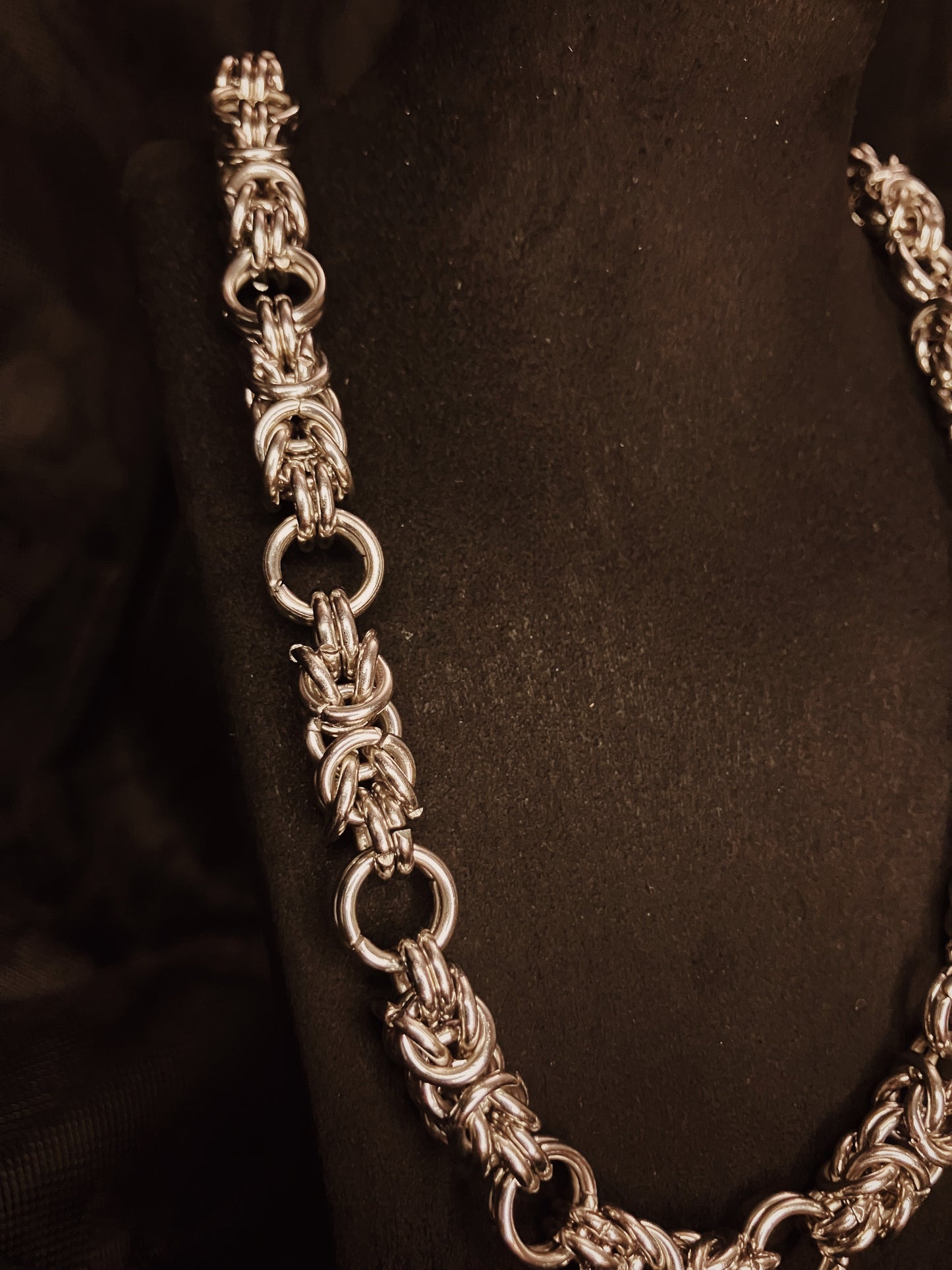Silver chain necklace on a black background