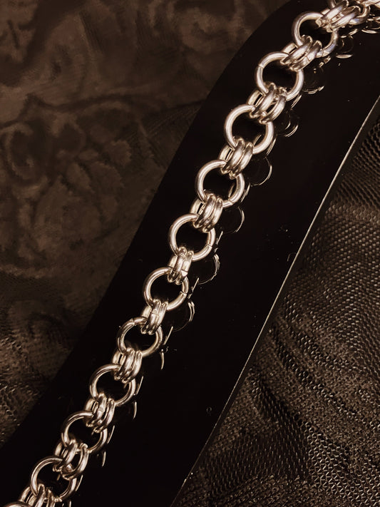 Silver chain bracelet on a textured brown surface
