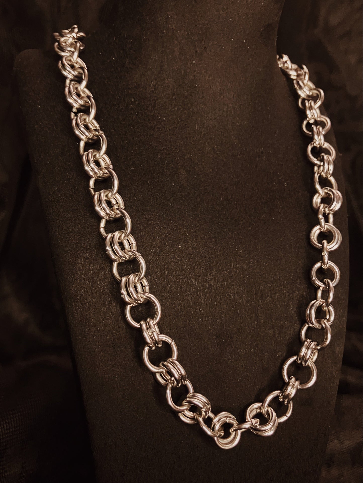 Silver chain necklace on a black mannequin bust