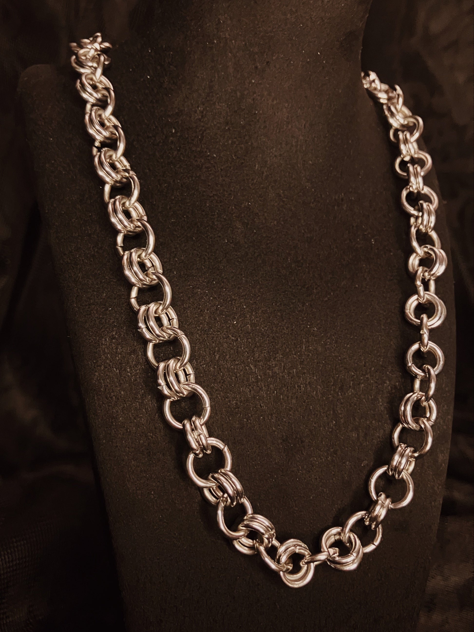 Silver chain necklace on a black mannequin bust