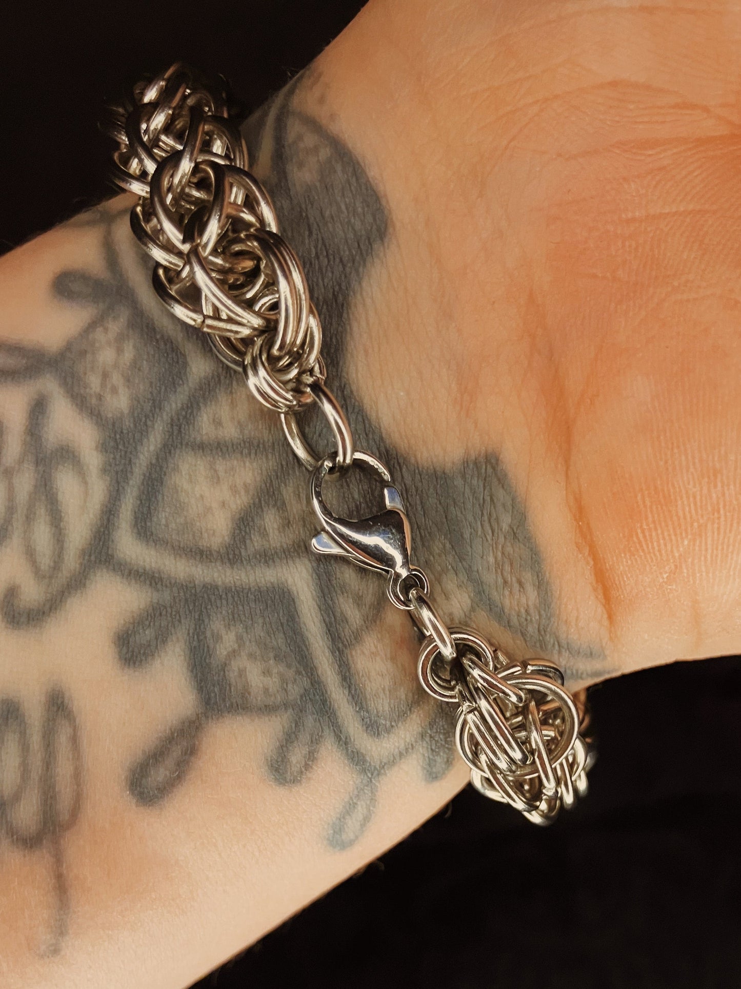 Bracelet with intricate design on a tattooed wrist