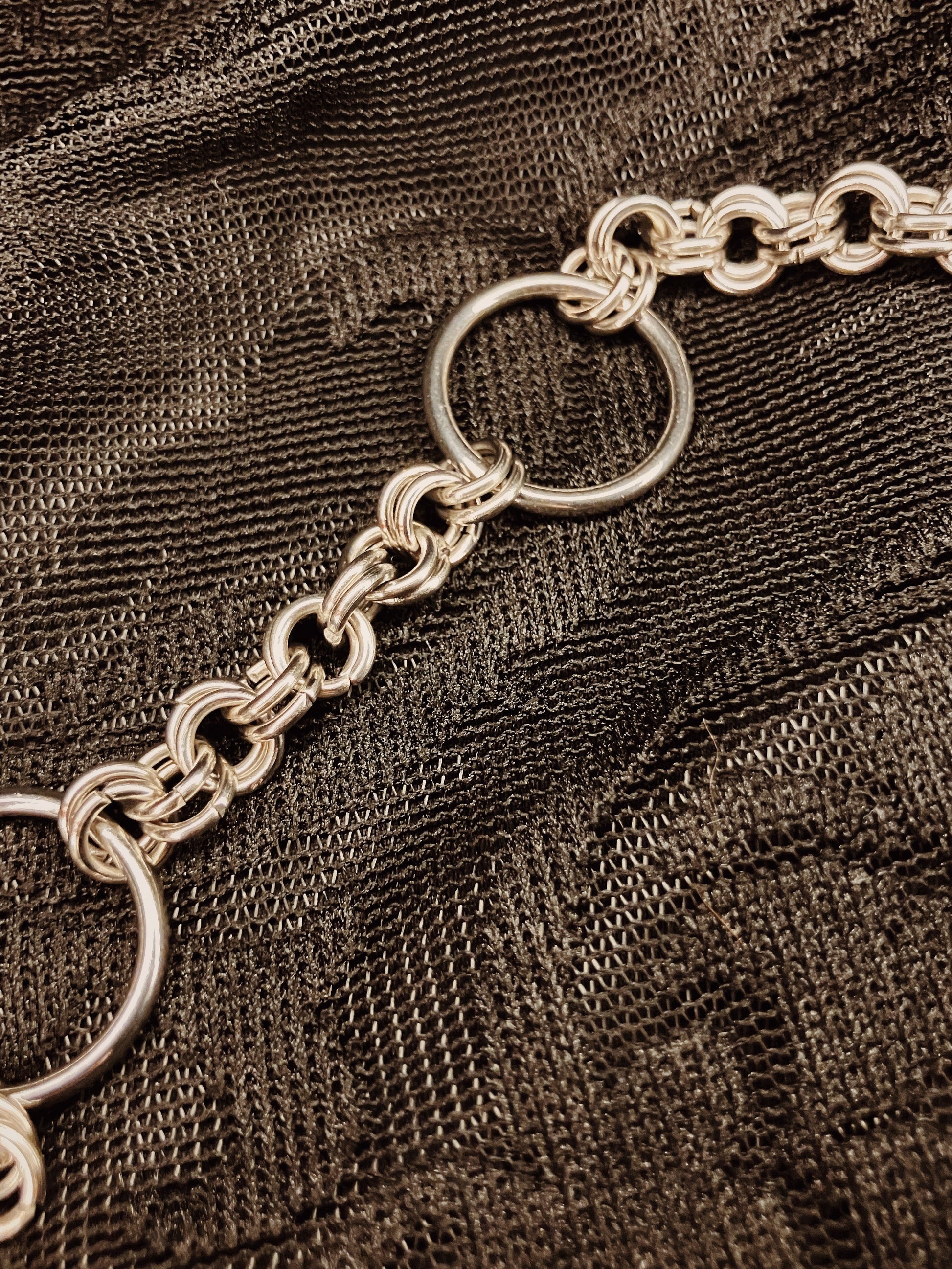 Silver chain on a textured brown fabric background