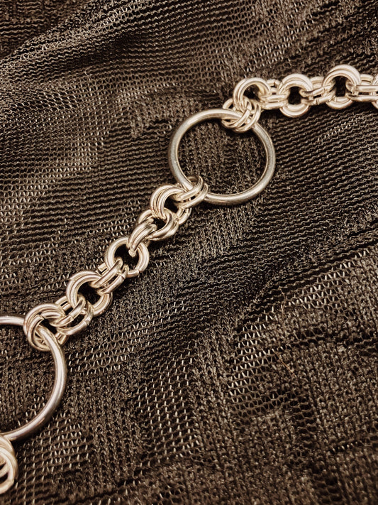 Silver chain on a textured brown fabric background