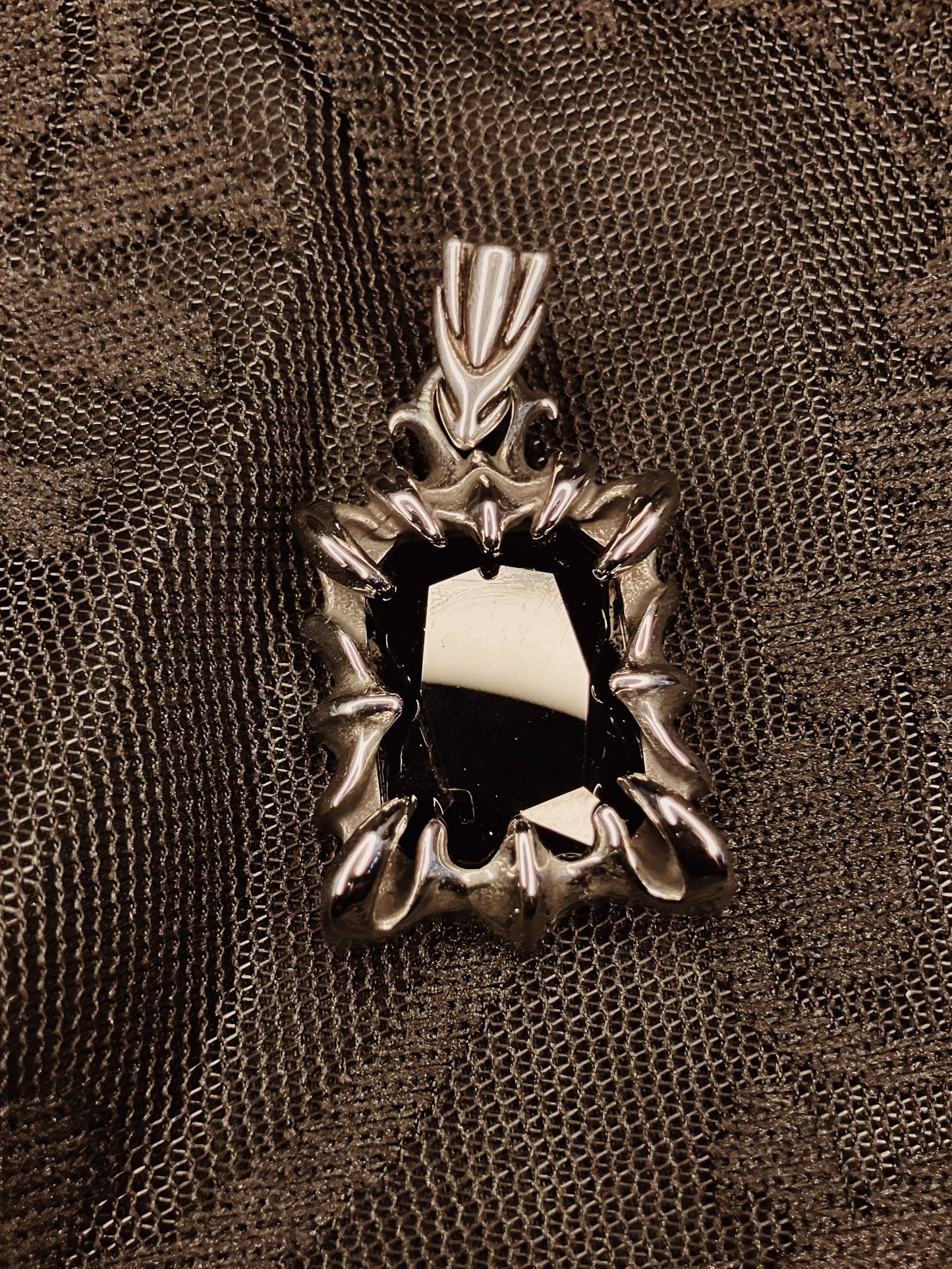 Decorative metal spiked pendant on a textured brown background