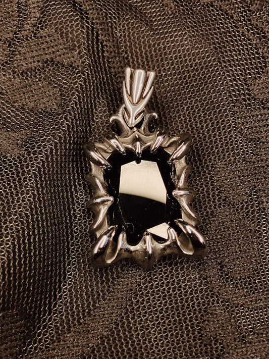 Decorative metal spiked pendant on a textured brown background