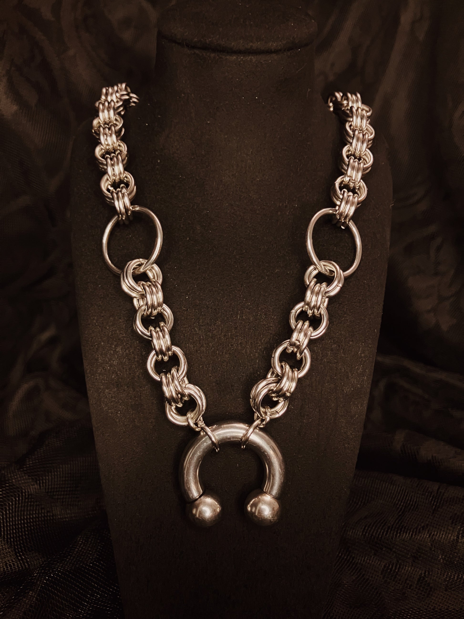 Silver chain necklace with a unique clasp on a black background