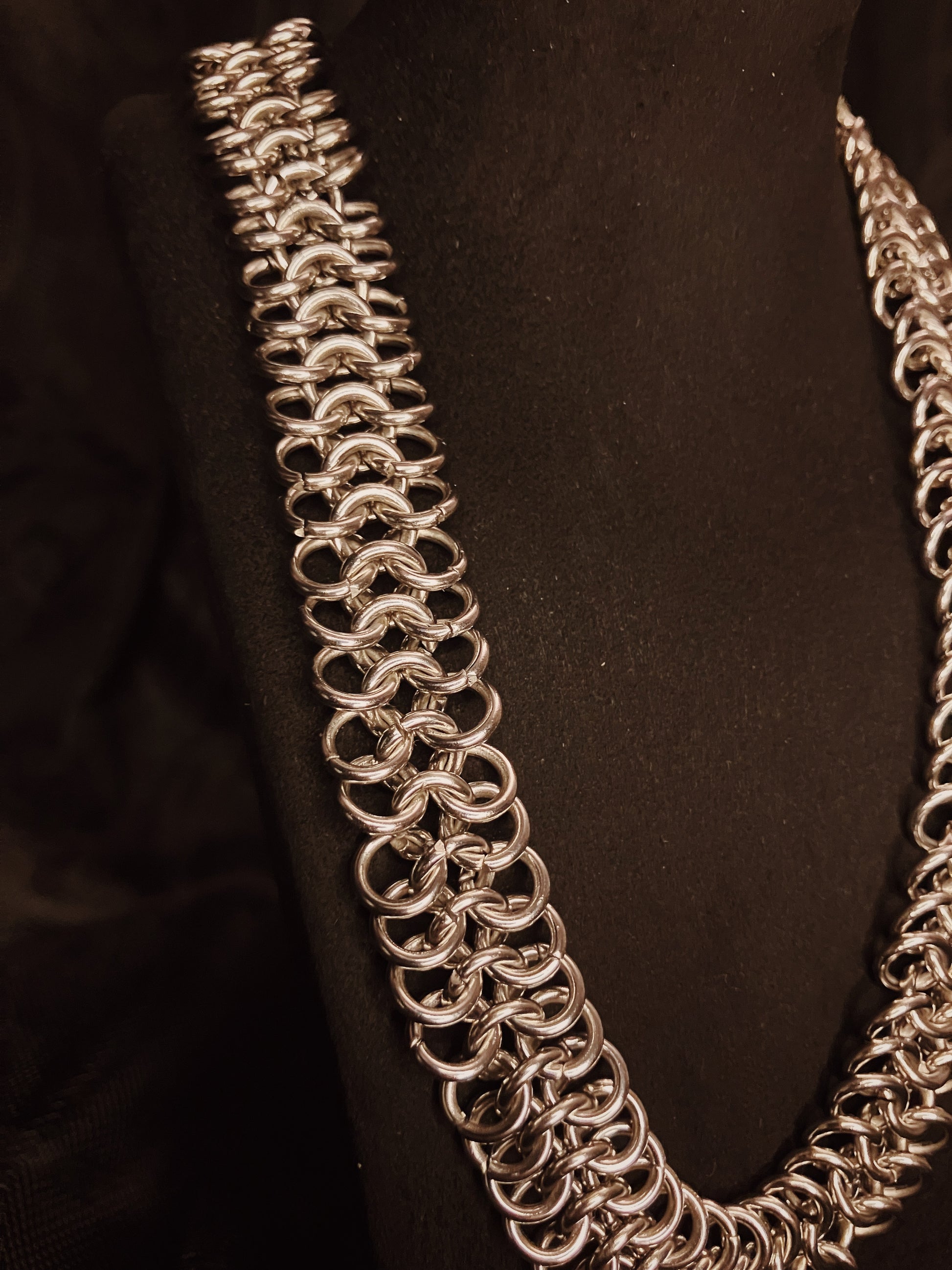 Silver chain necklace on a black background