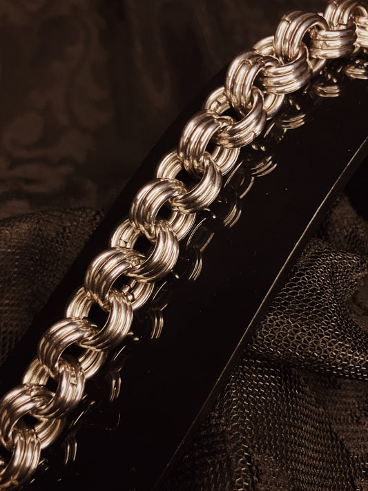 Close-up of a silver chain on a dark textured background