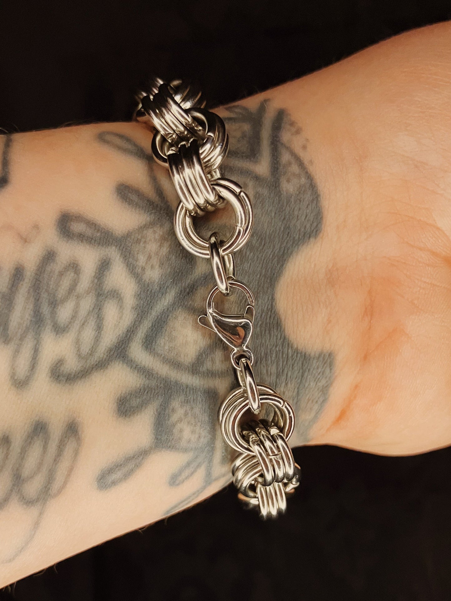 Silver bracelet  on a wrist with tattoos