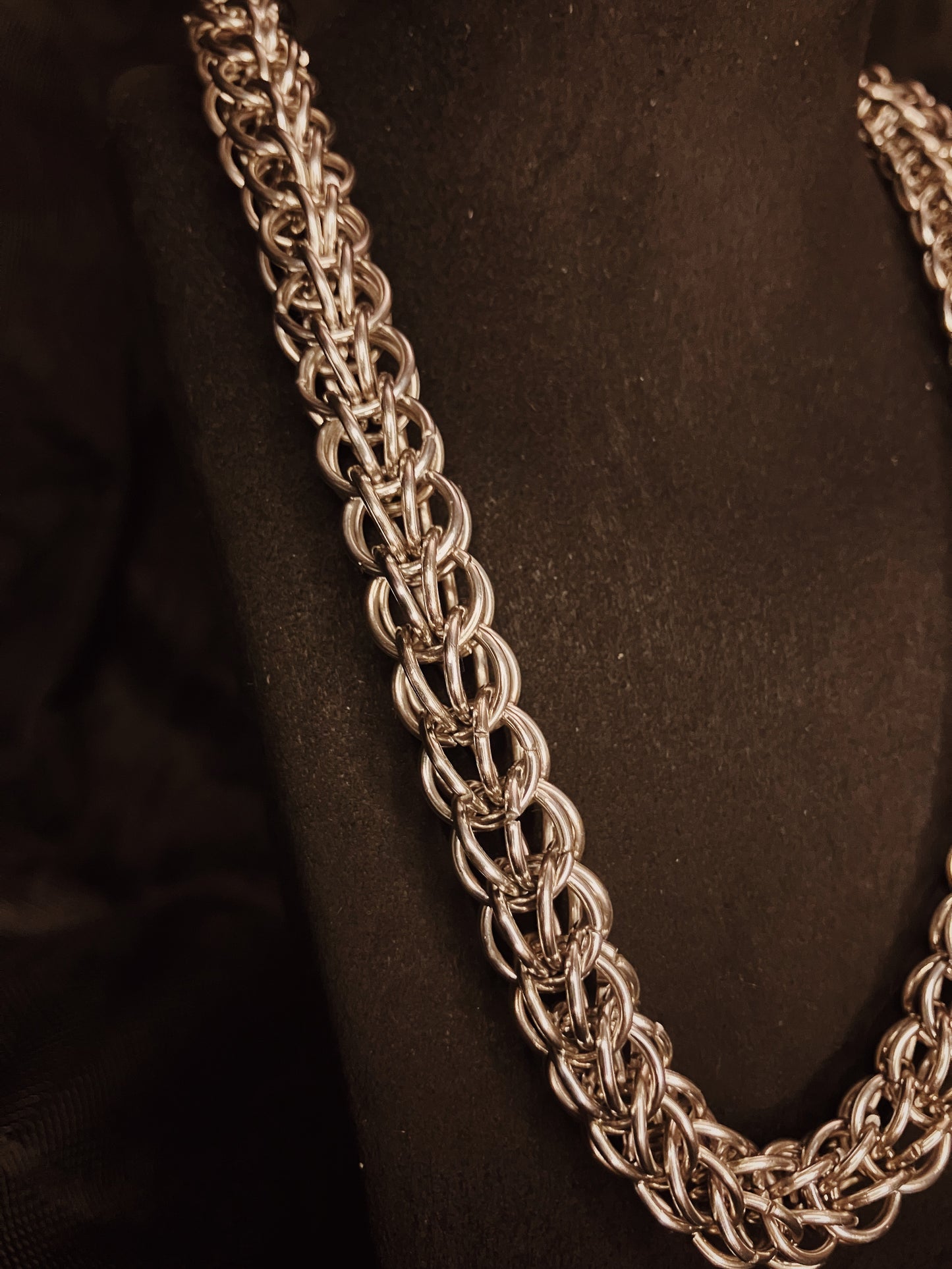 Close-up of a silver chain necklace on a black background