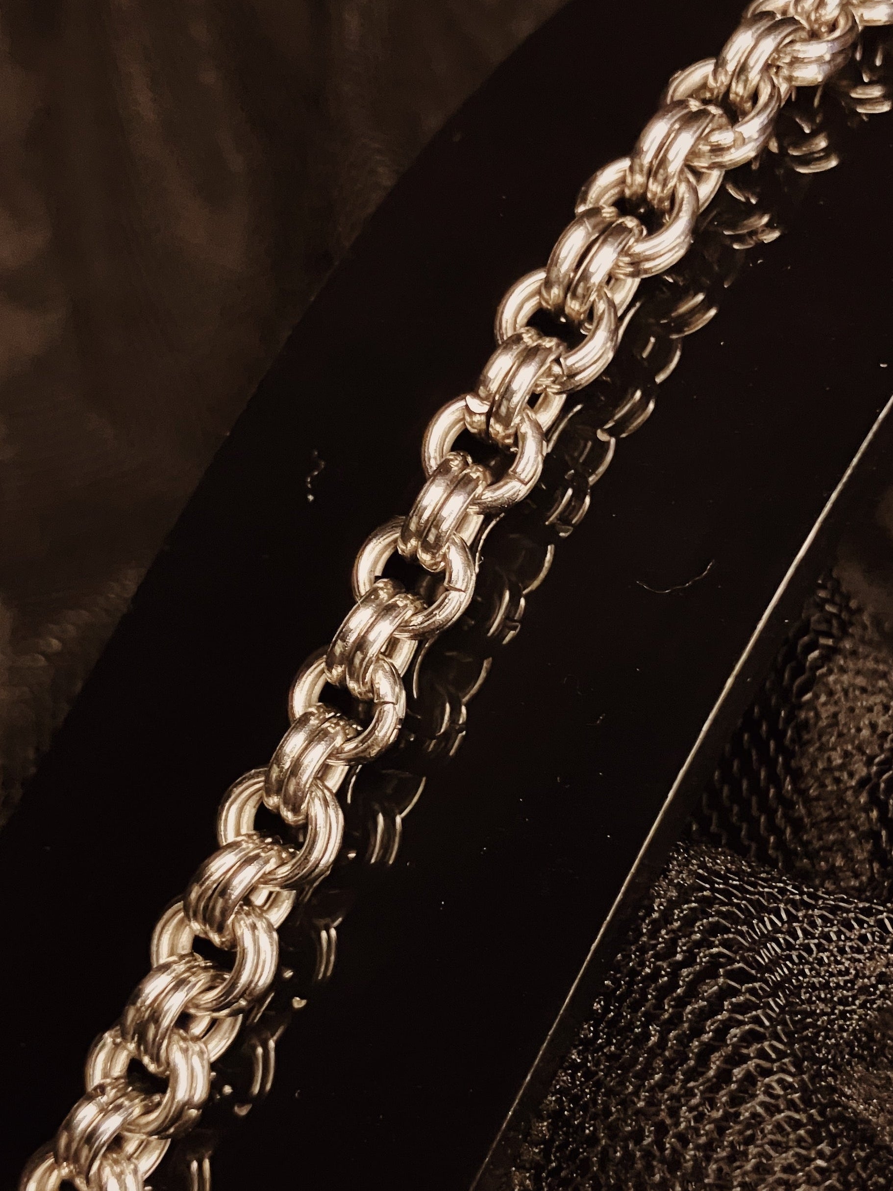 Close-up of a silver chain on a textured surface