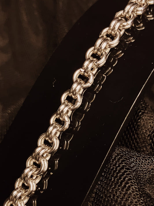 Close-up of a silver chain on a textured surface