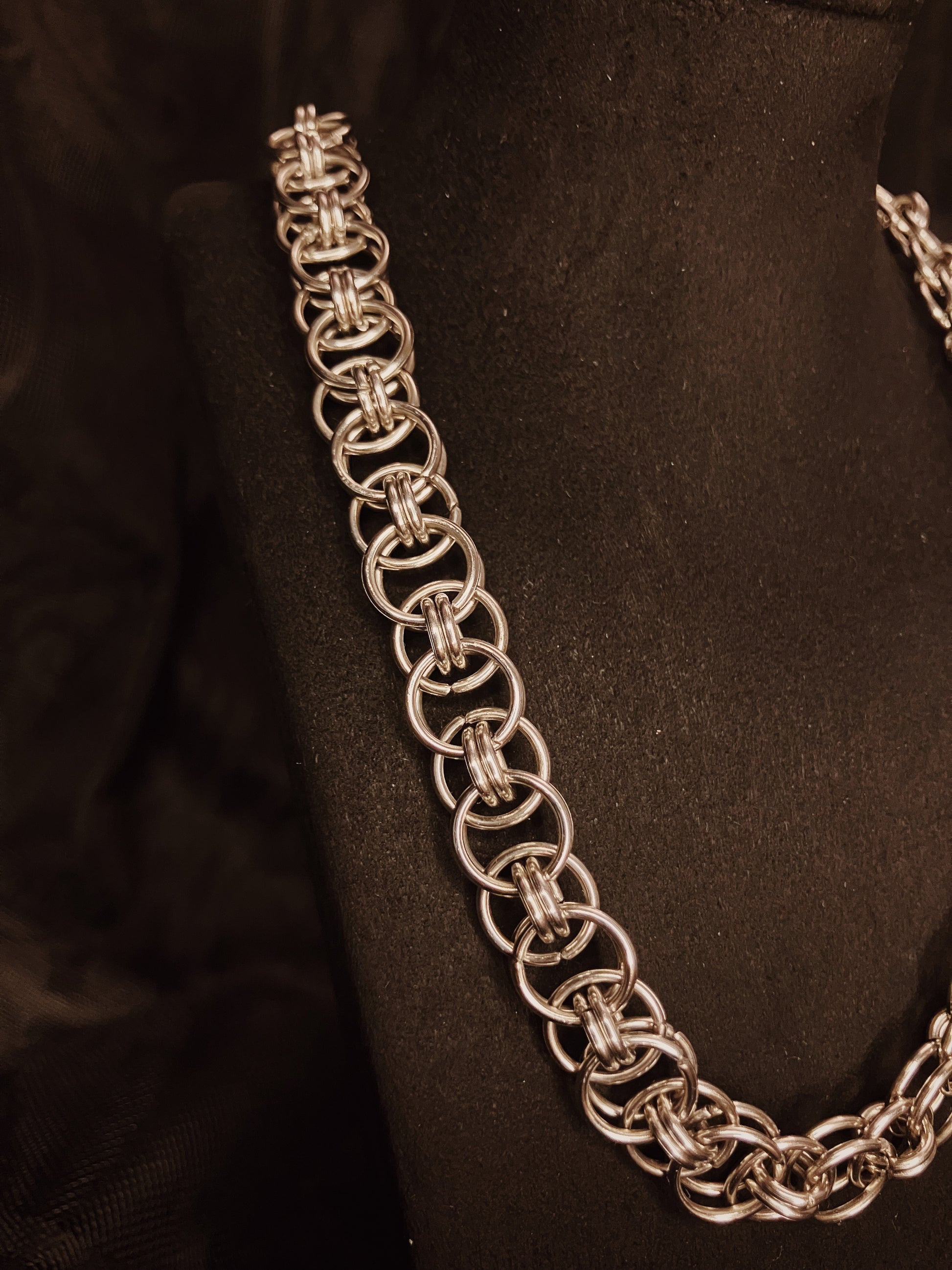 Silver chain necklace on a black background