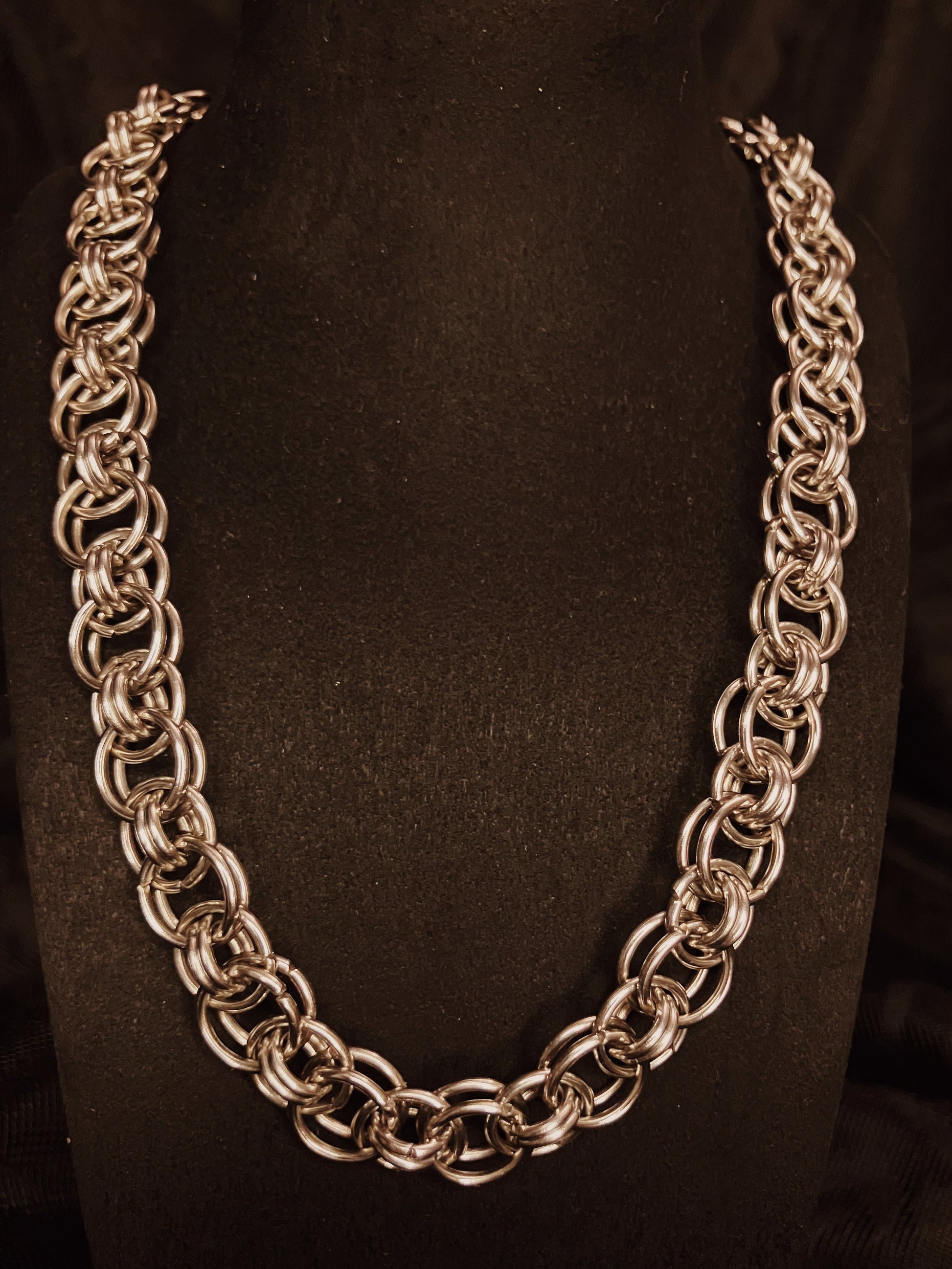 Silver chain necklace on a black background