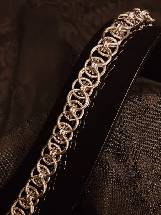 Silver chain bracelet on a textured black surface