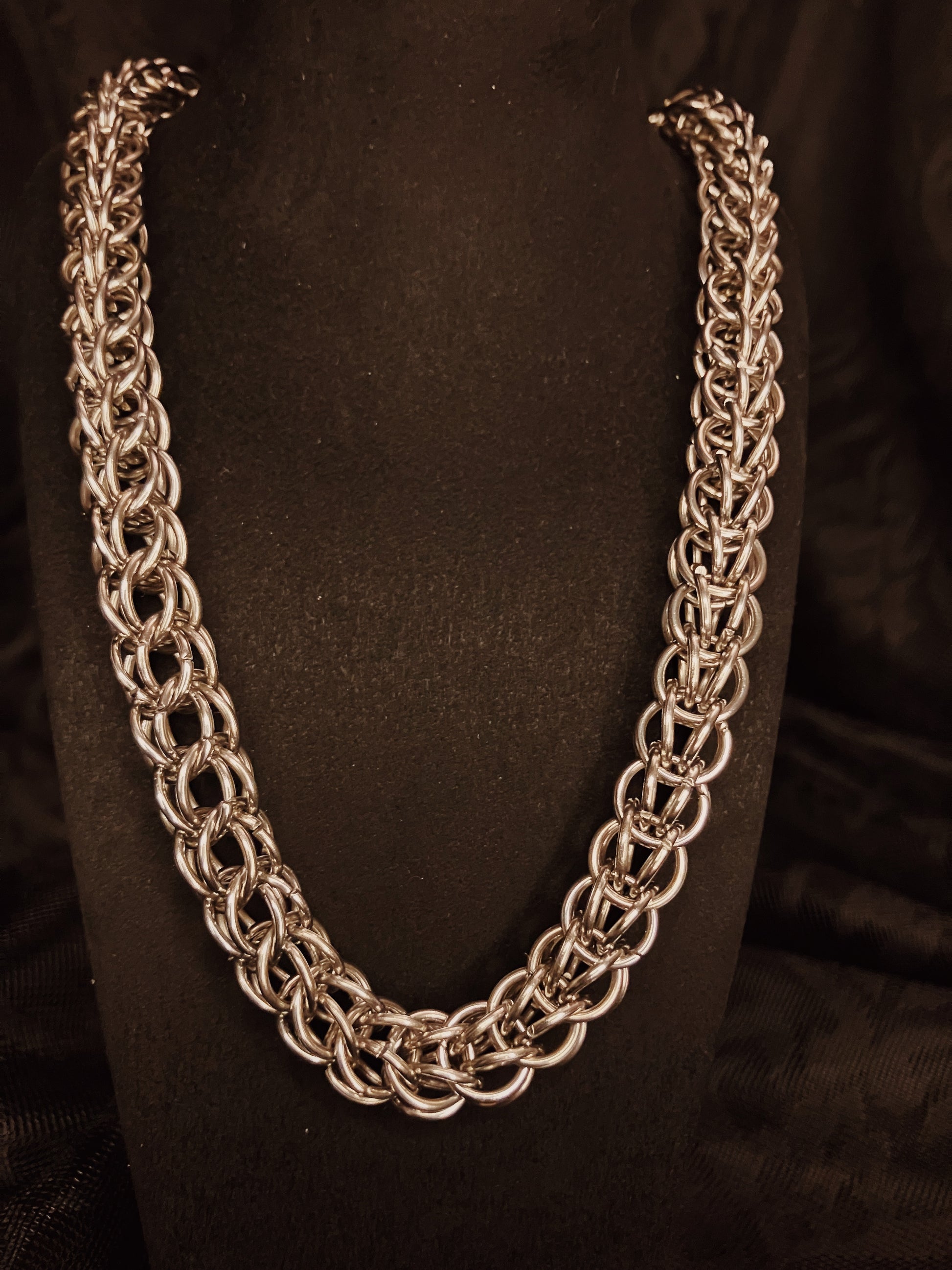 Silver chain necklace on a black background