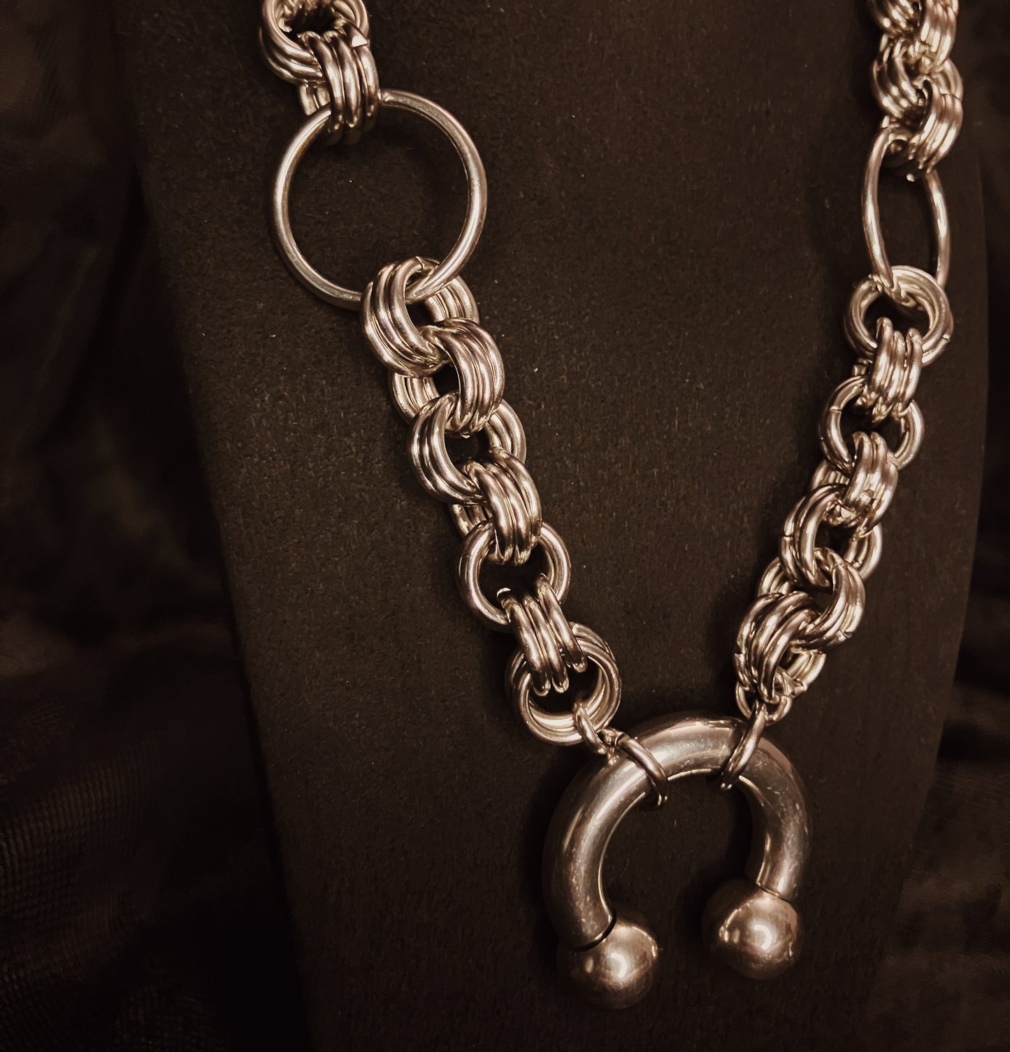 Silver chain necklace with a unique clasp on a dark background